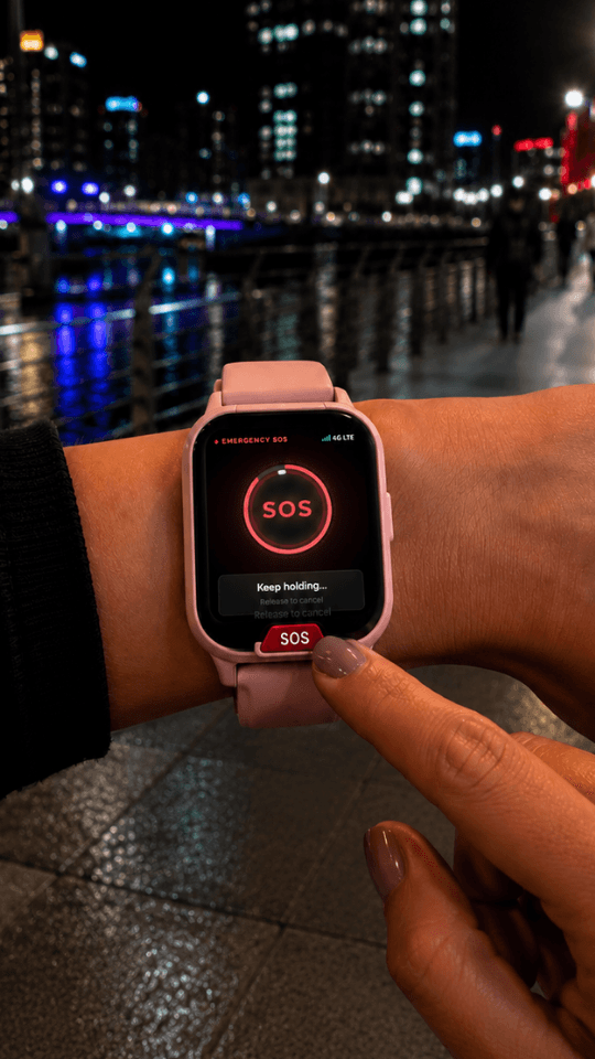 A person holding an emergency SOS button on a Guardiant smartwatch